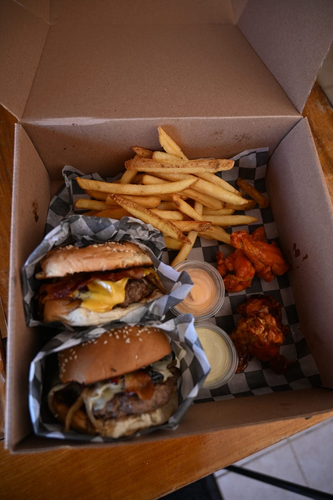 Una caja de The Burger Underground desde arriba: dos hamburguesas, papas y alitas
